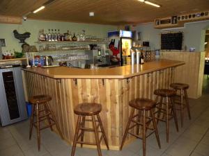 a wooden bar with stools in a kitchen at Hotel Restaurant Walliser Sonne in Reckingen - Gluringen +40 photos