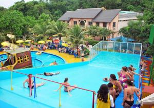 un grupo de personas en una piscina en un complejo en Pousada Ondas de Floripa, en Florianópolis