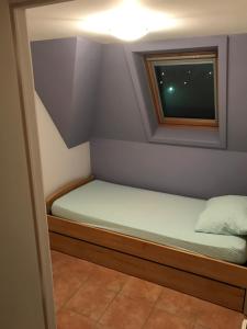 uma pequena cama num pequeno quarto com uma janela em Maison de vacances à Westende em Middelkerke
