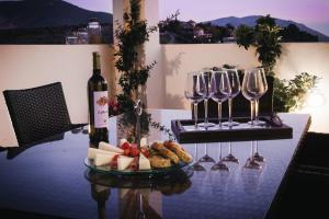 een tafel met een fles wijn en wijnglazen bij MiLo Luxury House -Free Airport pick up-10min drive in Markopoulon