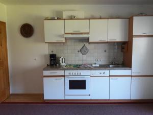 a kitchen with white cabinets and a white stove top oven at Haus Hauser Lofer 254 in Lofer