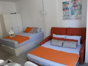 トレモリノスにあるLindo estudio en centro de Torremolinosのベッド2台、ベッド1台、ソファが備わる客室です。