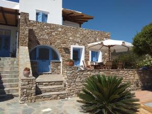 una casa in pietra con una porta blu e un patio di Despotiko View ad Agios Georgios
