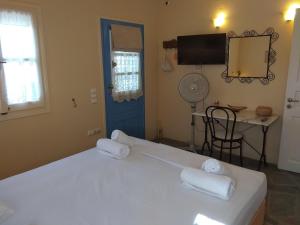 una camera da letto con un letto bianco e asciugamani di Despotiko View ad Agios Georgios