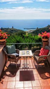 a patio with chairs and a table and the ocean at B&B Le Anthos in Marina di Camerota