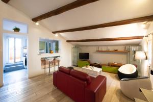 a living room with a red couch and a table at CasaJusta Trastevere in Rome