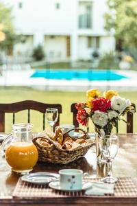 a table with a basket of flowers and a basket of bread at Villa Niagara in Chacras de Coria