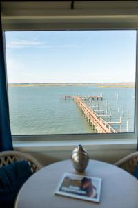 a table with a view of a pier from a window at Waterside Inn in Chincoteague