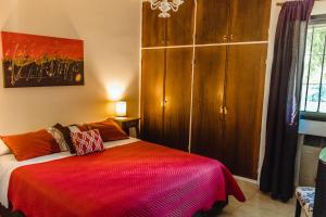 a bedroom with a bed with a red blanket at Villa Niagara in Chacras de Coria +69 photos