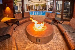 una sala de estar con una hoguera frente a una piscina en LivINN Hotel Cincinnati North/ Sharonville, en Sharonville