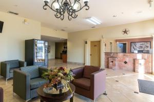 a living room with couches and a fireplace at Super 8 Dallas East Near Fair Park Downtown in Dallas