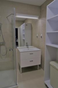 a bathroom with a white sink and a shower at Blue Sea Apartment in Kołobrzeg