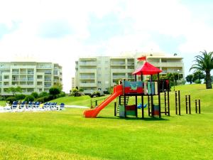 a playground in a park with a slide and chairs at Vila Marachique Torralvor in Alvor