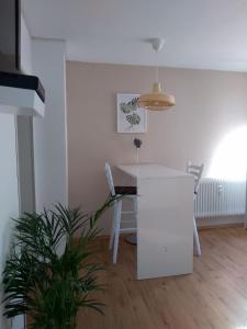 a dining room with a white table and a plant at Ferienwohnung Morbach in Morbach