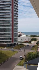 een uitzicht op een groot gebouw en een straat met auto's bij Chronos in Punta del Este