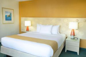 a large bed in a hotel room with two lamps at Coconut Waikiki Hotel in Honolulu +20 photos
