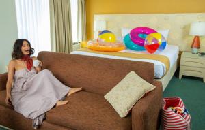 a woman sitting on a couch in a hotel room at Coconut Waikiki Hotel in Honolulu