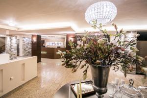 eine Vase mit Blumen auf einem Tisch in der Lobby in der Unterkunft Portaria Hotel in Portaria