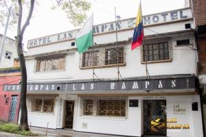 a building with two flags in front of it at Hotel Las Rampas in Medellín