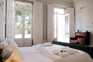 a bedroom with a bed with towels on it at Dona Emília Guest House & Studio Apartments in Viana do Castelo