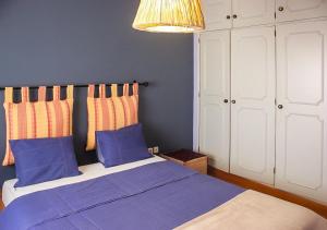 ラゴスにあるHeaven & Tashaのベッドルーム1室(青いシーツとランプ付)