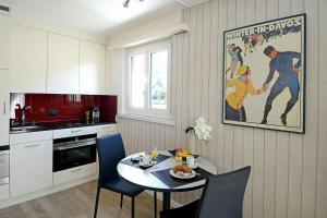 una cocina con mesa y sillas y una pintura en la pared en Studio 25 Davos Platz en Davos