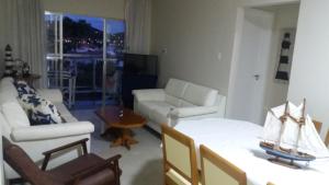 sala de estar con sofá blanco y mesa en COSTA DO SOL, en Cabo Frío