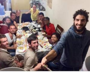 un grupo de personas sentadas alrededor de una mesa comiendo en Estancia 311 Backpackers, en Cajamarca