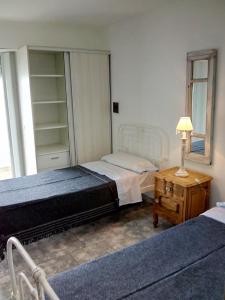 a bedroom with two beds and a table with a lamp at DTO SERRANO in Tandil