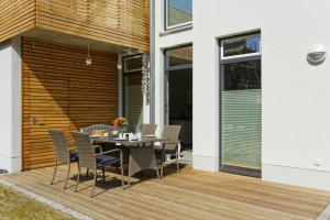 a patio with a table and chairs on a wooden deck at Kapitaensweg 2 Kajuete 03 in Ostseebad Karlshagen