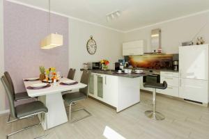 een keuken met een tafel en stoelen in een kamer bij Kapitaensweg 2 Kajuete 03 in Ostseebad Karlshagen