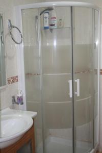 una ducha con una puerta de cristal junto a un lavabo en Don Pelayo, en Barbate
