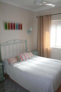 Un dormitorio con una cama blanca y una ventana. en Don Pelayo, en Barbate