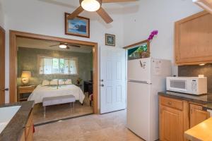 a kitchen with a bed and a white refrigerator at Mango Retreat in Kailua-Kona