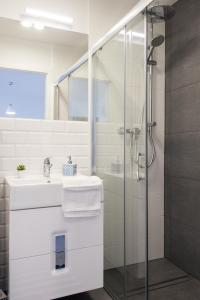 a white bathroom with a sink and a shower at Legnica Apartament 52m2 Delux 1 in Legnica