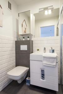a white bathroom with a toilet and a sink at Legnica Apartament 52m2 Delux 1 in Legnica