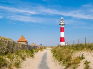 a red and white lighthouse sitting on the beach at Zandduin in Nieuwpoort