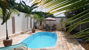 a swimming pool on a patio with chairs and an umbrella at Villa Belo Quinto Spa & Spazzio Bloco 2 in Brotas