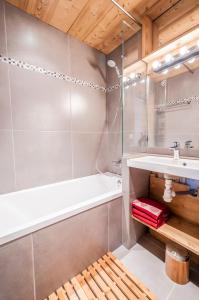 a bathroom with a bath tub and a sink at Val Thorens-Cosy Appartement avec vue Vanoise 566 in Val Thorens