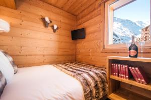 a bedroom with a bed in a wooden room with a window at Val Thorens-Cosy Appartement avec vue Vanoise 566 in Val Thorens +14 photos