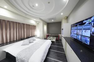 a bedroom with a large bed and a flat screen tv at Hotel Sen (Adult Only) in Osaka