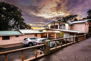 dos autos estacionados frente a una casa en Mar Inn Costa Rica, en Monteverde