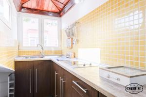a kitchen with yellow tiled walls and a sink at Charming Fuencarral Street in Madrid
