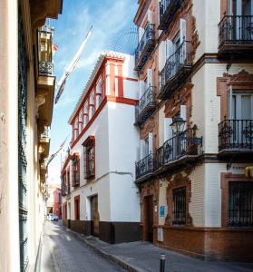 an empty street in a city with buildings at Suites Machado in Seville
