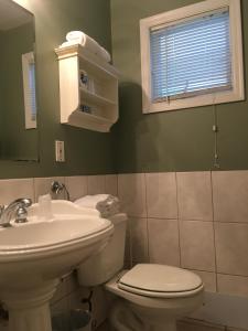Westhampton Seabreeze Motel في Westhampton: حمام مع حوض ومرحاض ومرآة