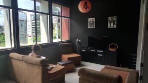 a child sitting in a chair in a living room at Borneo Sweet Guesthouse in Kuching