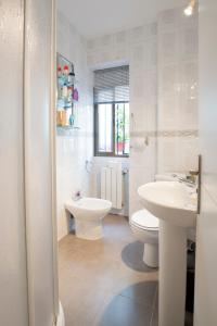 biała łazienka z toaletą i umywalką w obiekcie Apartamento Albaycin Granada w Grenadzie