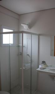 a bathroom with a glass shower and a sink at Boulevard Jaguari in Igaratá