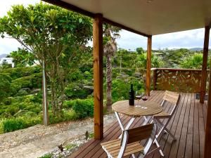 a patio with a table and chairs on a deck at Piha Tiny House in Piha