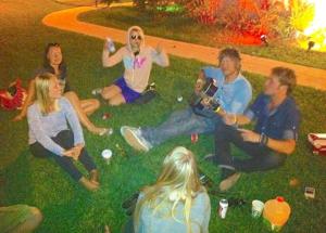 Un groupe de personnes assises dans l'herbe dans l'établissement Bikini Hostel, Cafe & Beer Garden, à Miami Beach